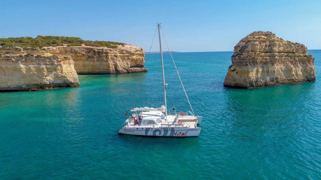 Beautiful sailing catamaran in front of the coast of Albufeira