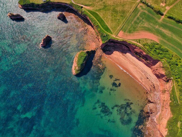 Aerial view of Ladram Bay's cliffs and turquoise waters in Devon