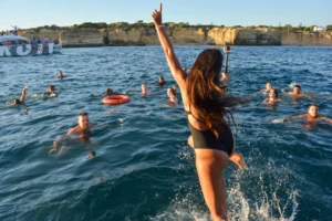 Girl jumping into the sea during a boat party in Portimão
