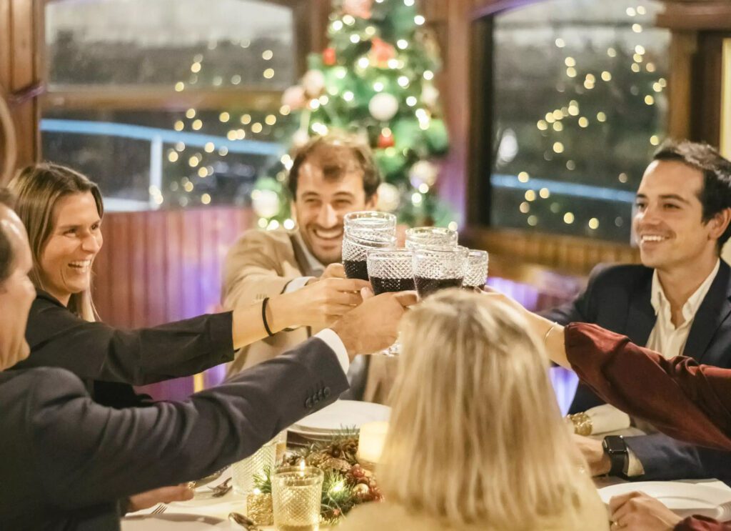 Guests enjoying a festive Christmas party with drinks and food on the historic EVORA boat in Lisbon