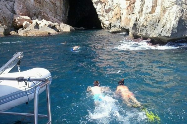 Mensen die zwemmen bij de grotten in Denia