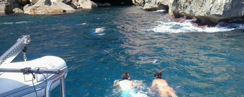 Mensen die zwemmen bij de grotten in Denia
