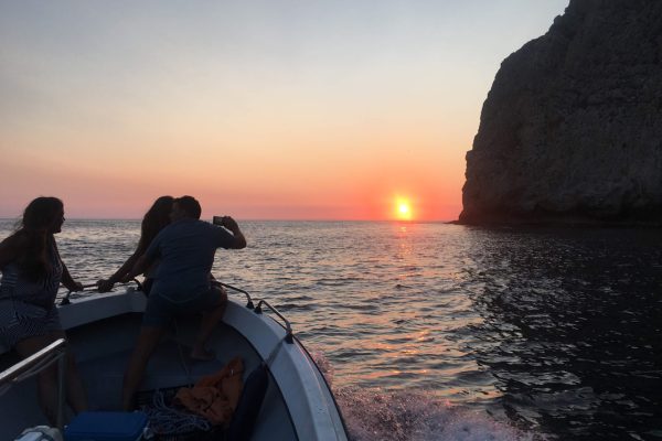 Mensen op een boot die de zonsondergang in Sesimbra bekijken