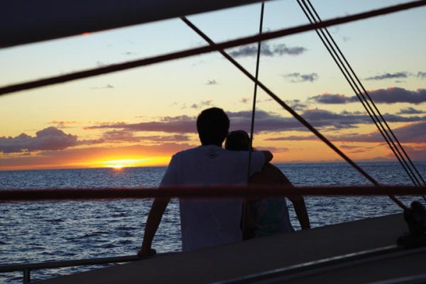 couple enjoying a sunset on a boat.