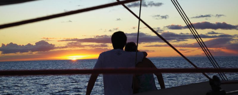 couple enjoying a sunset on a boat.