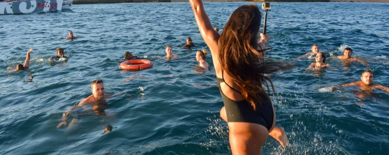 Girl jumping into the sea during a boat party in Portimão