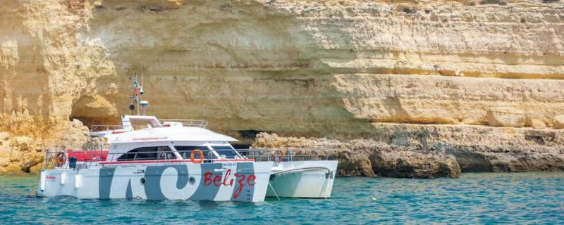 Big mototr vatamaran in front of rock formations of Vilamoura
