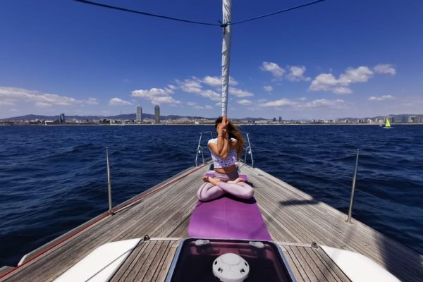 Postura de yoga en velero en Barcelona