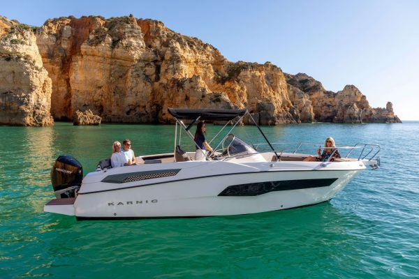 The white Karnic SL701 private boat 'Snowwhite' at anchor near the cliffs of Lagos, Algarve.